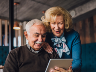 elderly couple looking at an electronic tablet