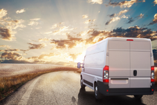White van driving into a sunset