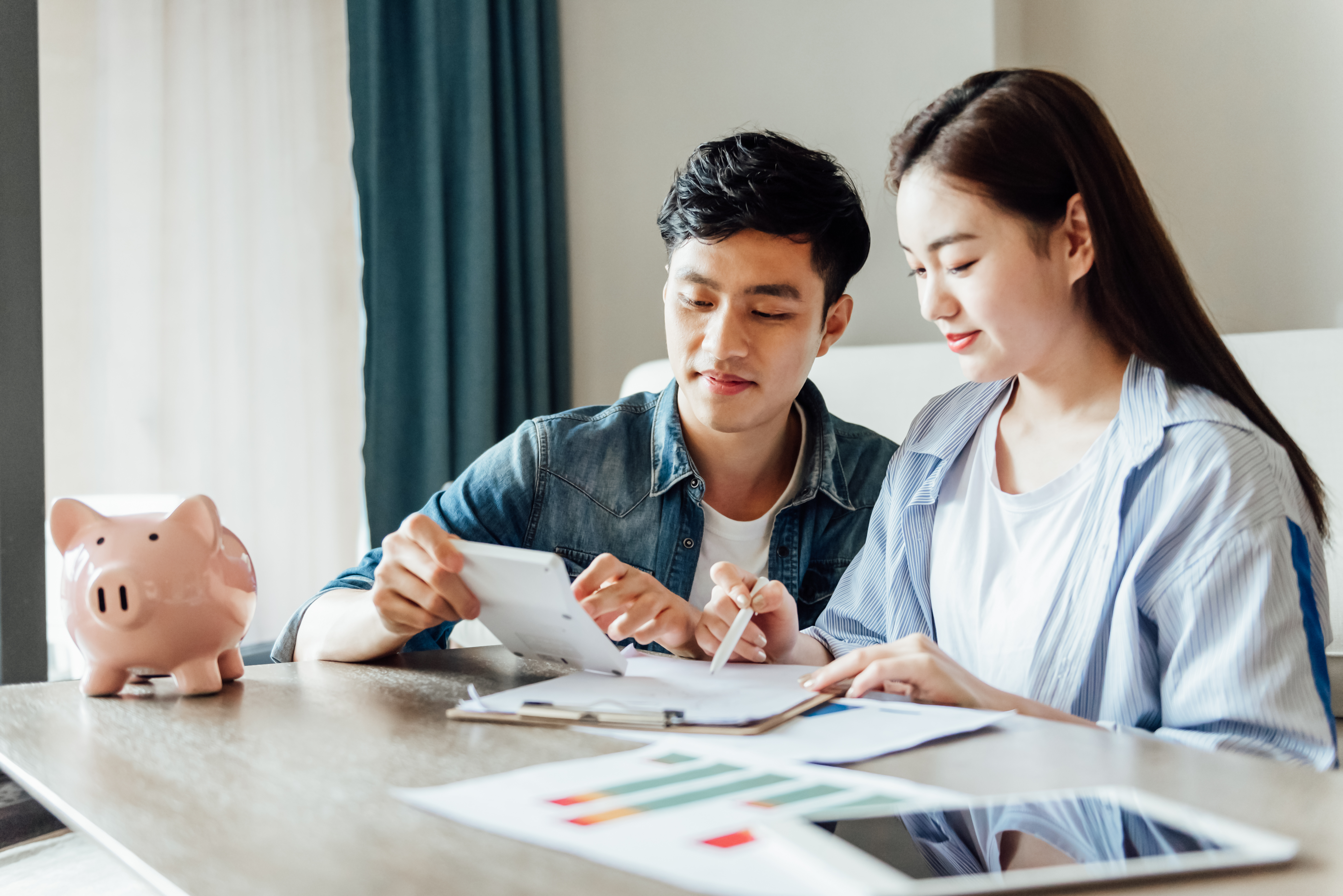young couple sitting at a table discussing paperwork