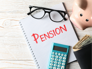 Pension written in red pen on a notebook beside a calculator and piggy bank