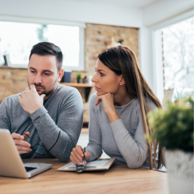 two people discussing over a laptop