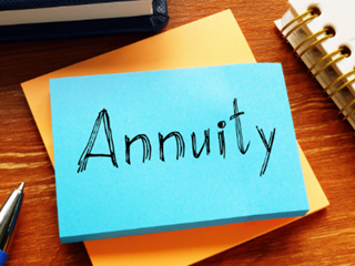 Blue sticky note on a desk with the word 'Annuity' written on it