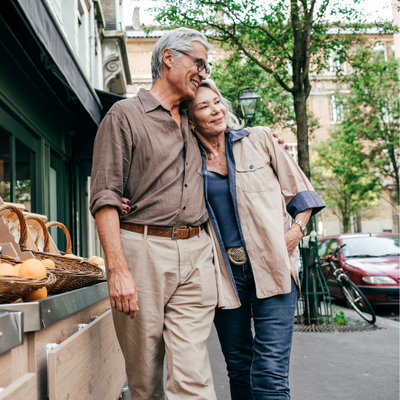 happy retired couple walking through a market