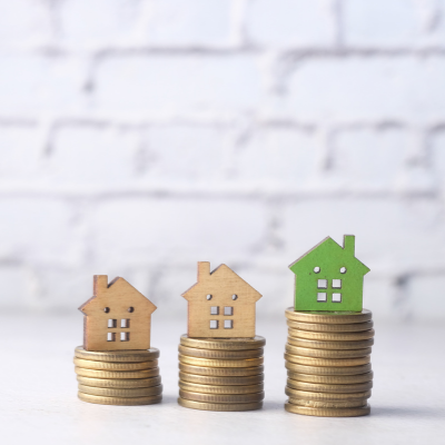 wooden houses on top of stacked coins
