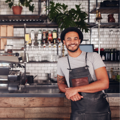 cafe owner smiling at the counter of his shop