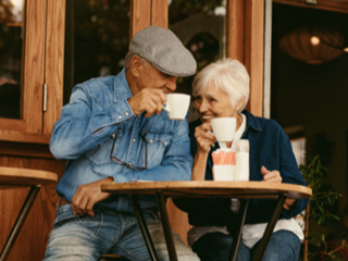 elderly couple drinking coffee outside