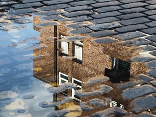 House reflected in a puddle of water