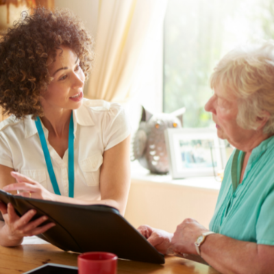 Two women conversing over paperwork