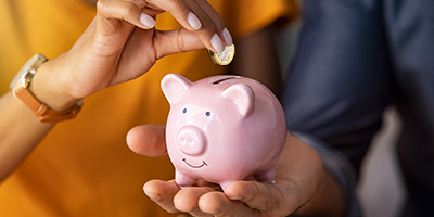 Holding piggy bank plus coin