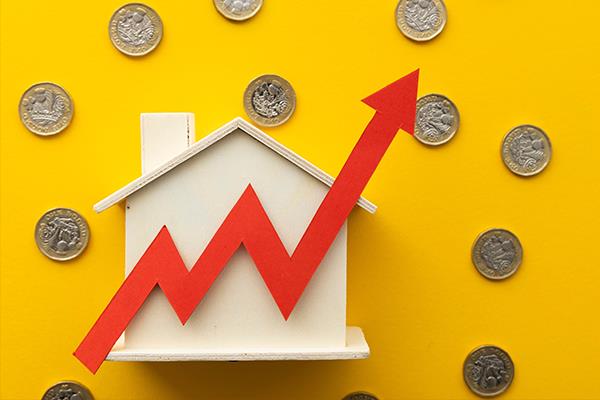Wooden house surrounded by pound coins and upwards arrow.