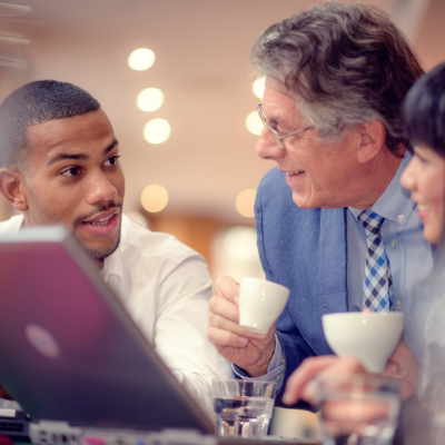 Three people talking over coffee