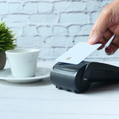 person paying for goods using their bank card on the reader